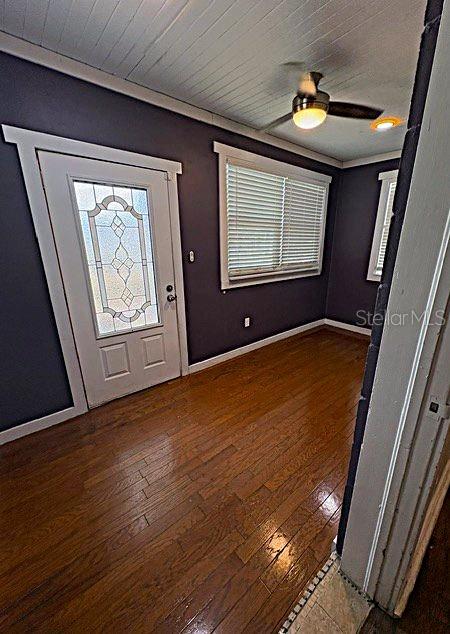 A room with dark walls, hardwood floors, a white door with glass, and a ceiling fan — 1002 OAKHILL STREET, LAKELAND, FL