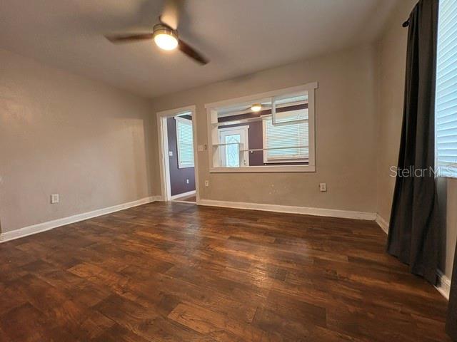 A living room with wood-look flooring, a ceiling fan, and a pass-through window — 1002 OAKHILL STREET, LAKELAND, FL