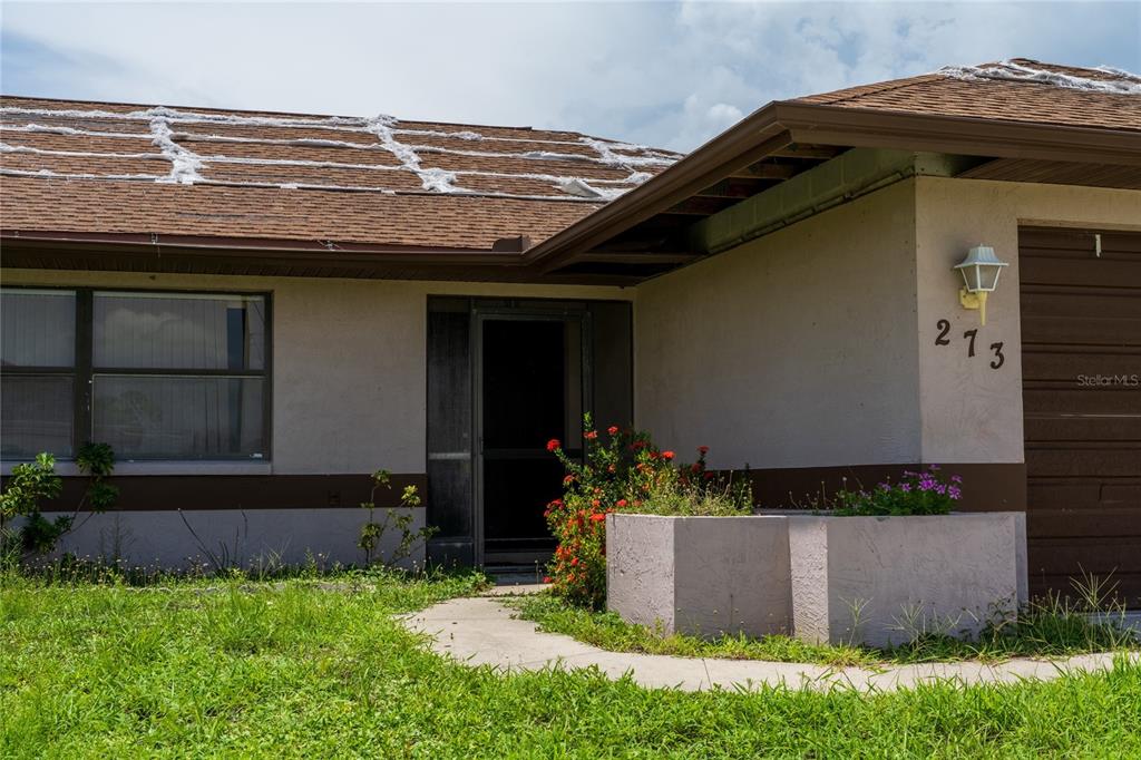 A single-story house exterior features a brown roof with white patches and a front entrance — 273 ROTONDA CIRCLE, ROTONDA WEST, FL