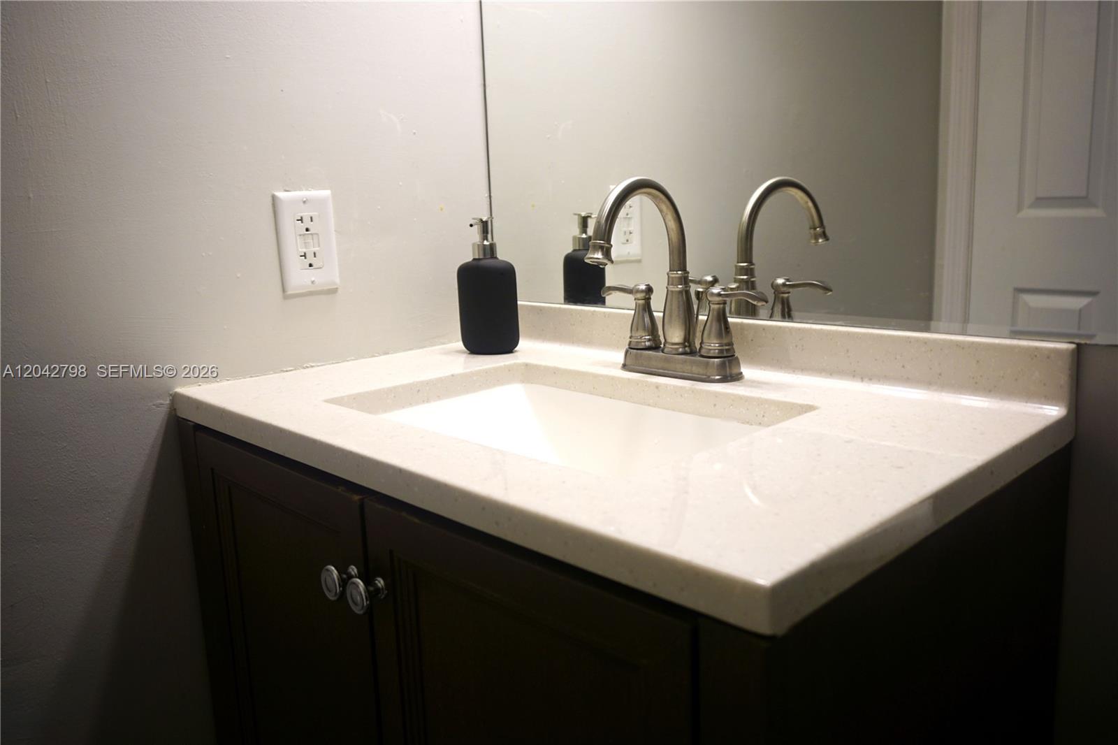 A bathroom vanity features a white countertop, a rectangular sink, and a brushed nickel faucet — 914 SW 8th Avenue # 57, Gainesville FL 32601, GAINESVILLE, FL