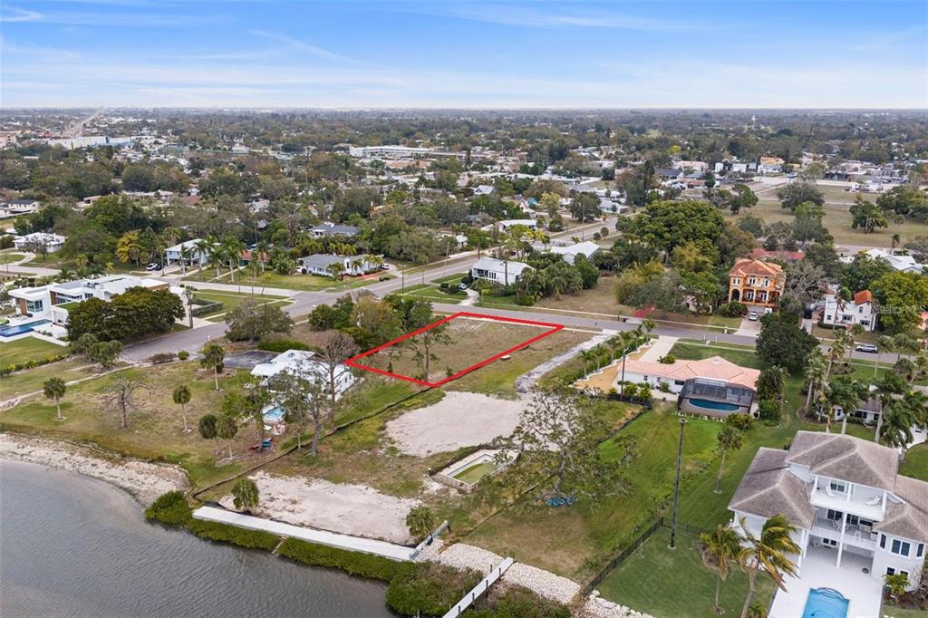 An aerial view shows a vacant rectangular waterfront lot outlined in red — 7510 WESTMORELAND DRIVE, SARASOTA, FL