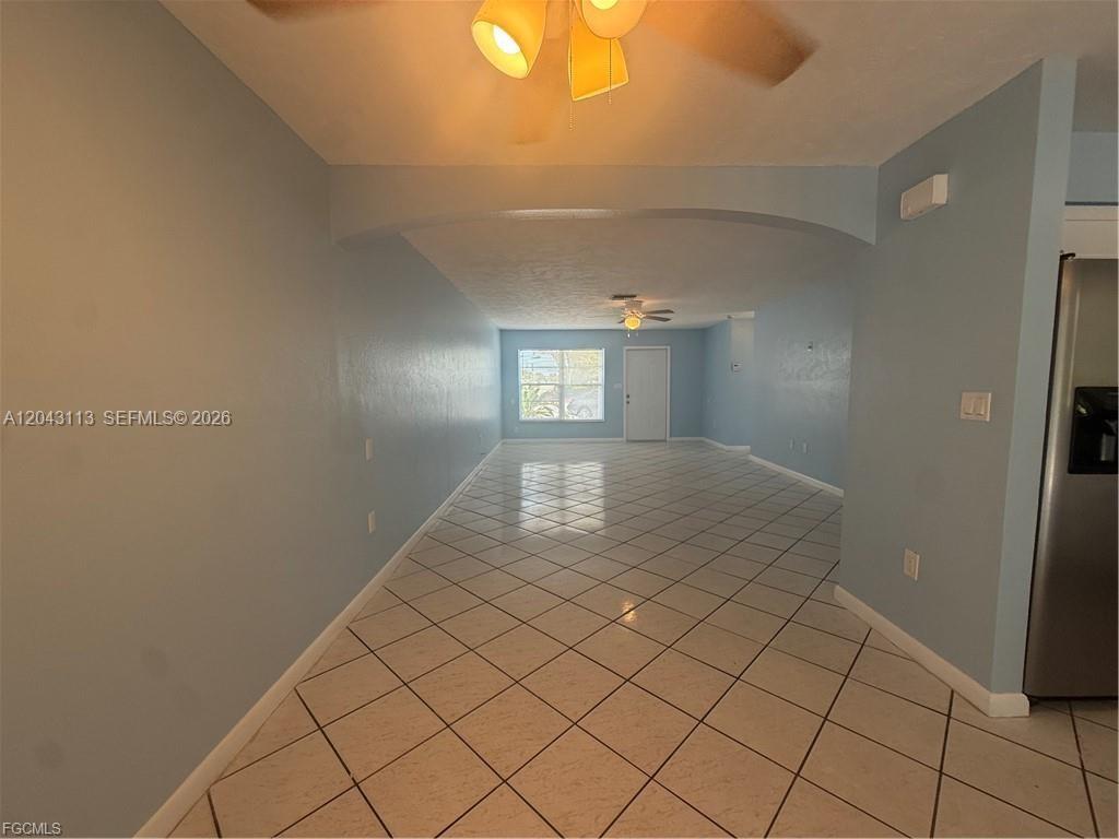 An interior view shows a long, light blue room with diagonal white floor tiles — 257 CAPE CORAL PKY E # B, Cape Coral FL 33904, CAPE CORAL, FL