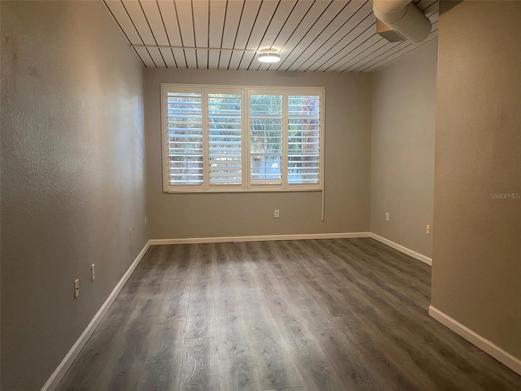 An empty room features gray walls, wood-look flooring, and a white slatted ceiling — 520 S ARMENIA AVENUE UNIT 1228, TAMPA, FL