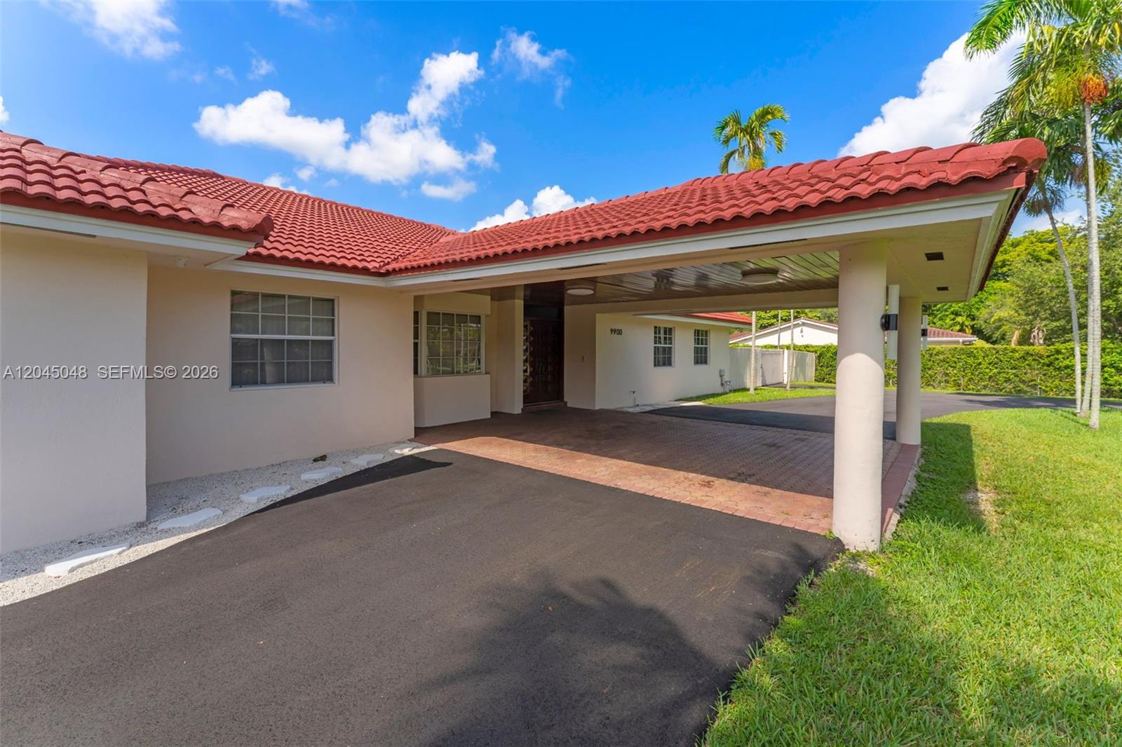 A single-story house with a red tile roof sits behind a large green lawn — 9900 SW 62nd St, Miami FL 33173, MIAMI, FL