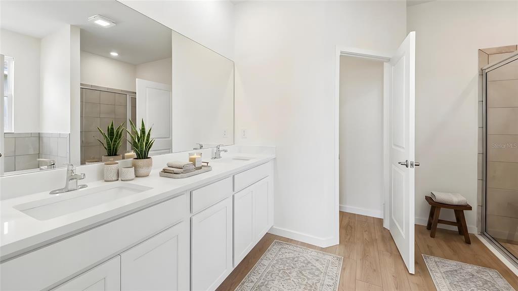 A modern bathroom features a white double vanity, a large mirror, and a glass shower — 4550 NW 39TH STREET ROAD, OCALA, FL