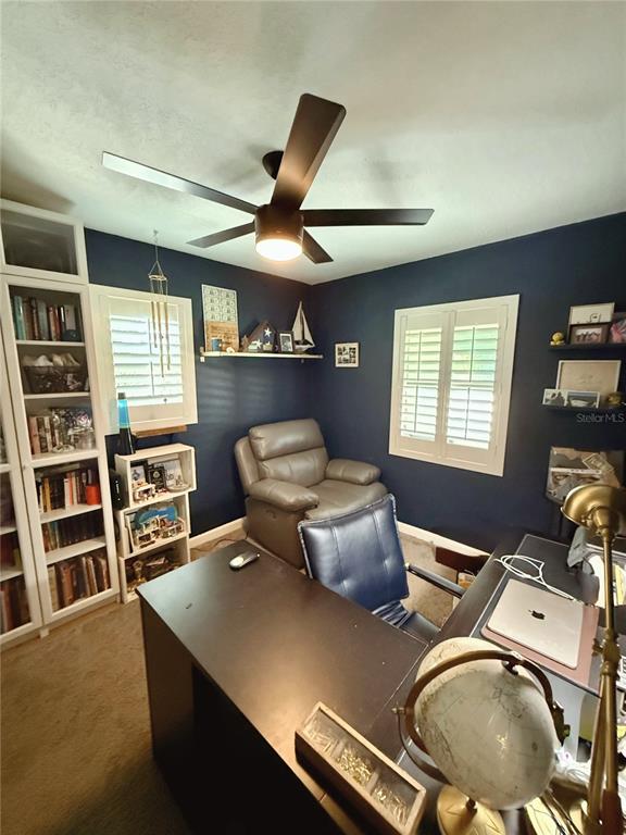 A home office features dark blue walls, a ceiling fan, a desk, and a bookshelf — 2623 14TH AVENUE N, ST PETERSBURG, FL