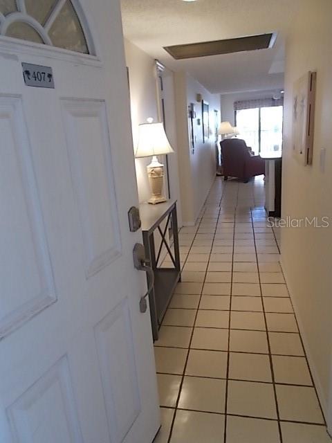 An entryway leads into a tiled hallway with a console table and a distant living area — 14001 GULF BOULEVARD UNIT 407, MADEIRA BEACH, FL