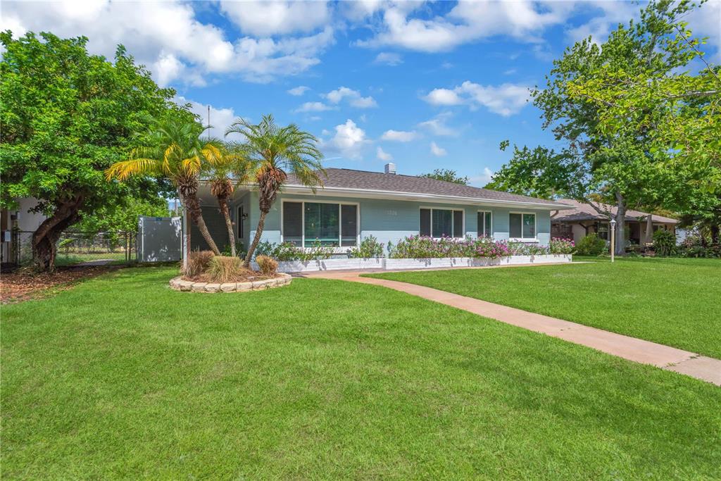 A light blue single-story house with a palm tree and a front lawn — 1306 30TH STREET W, BRADENTON, FL