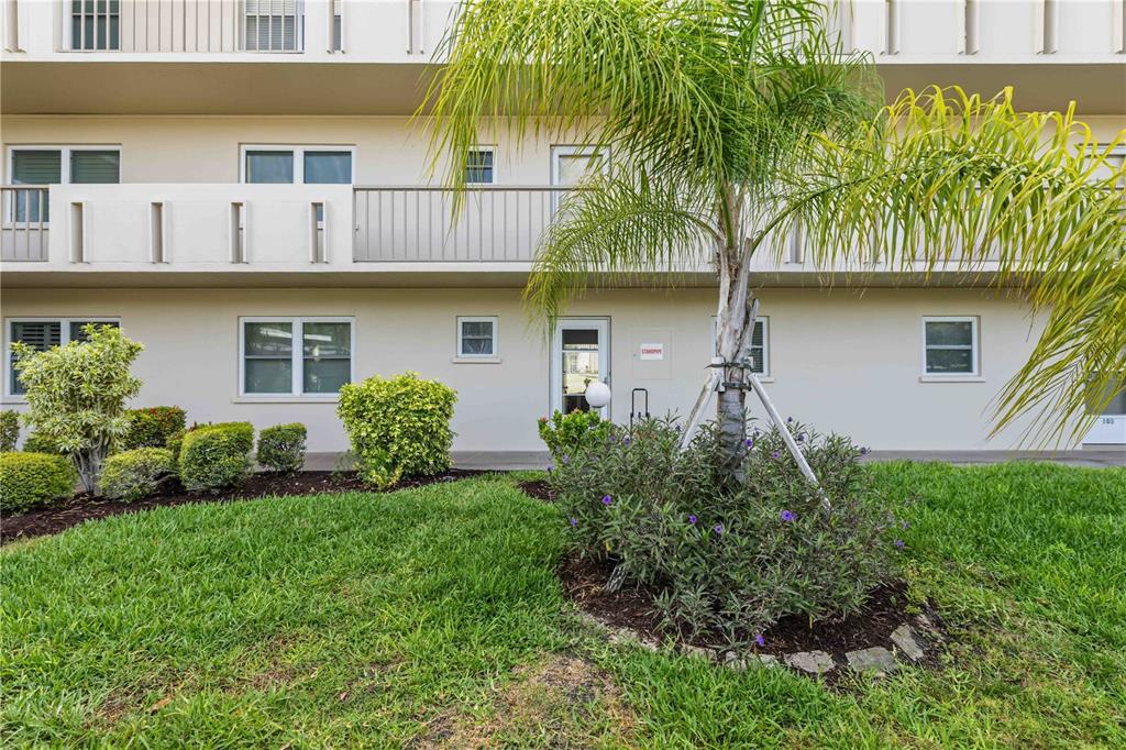 A palm tree stands in front of a two-story apartment building with a ground-level walkway — 3680 IRONWOOD CIRCLE UNIT 202L, BRADENTON, FL