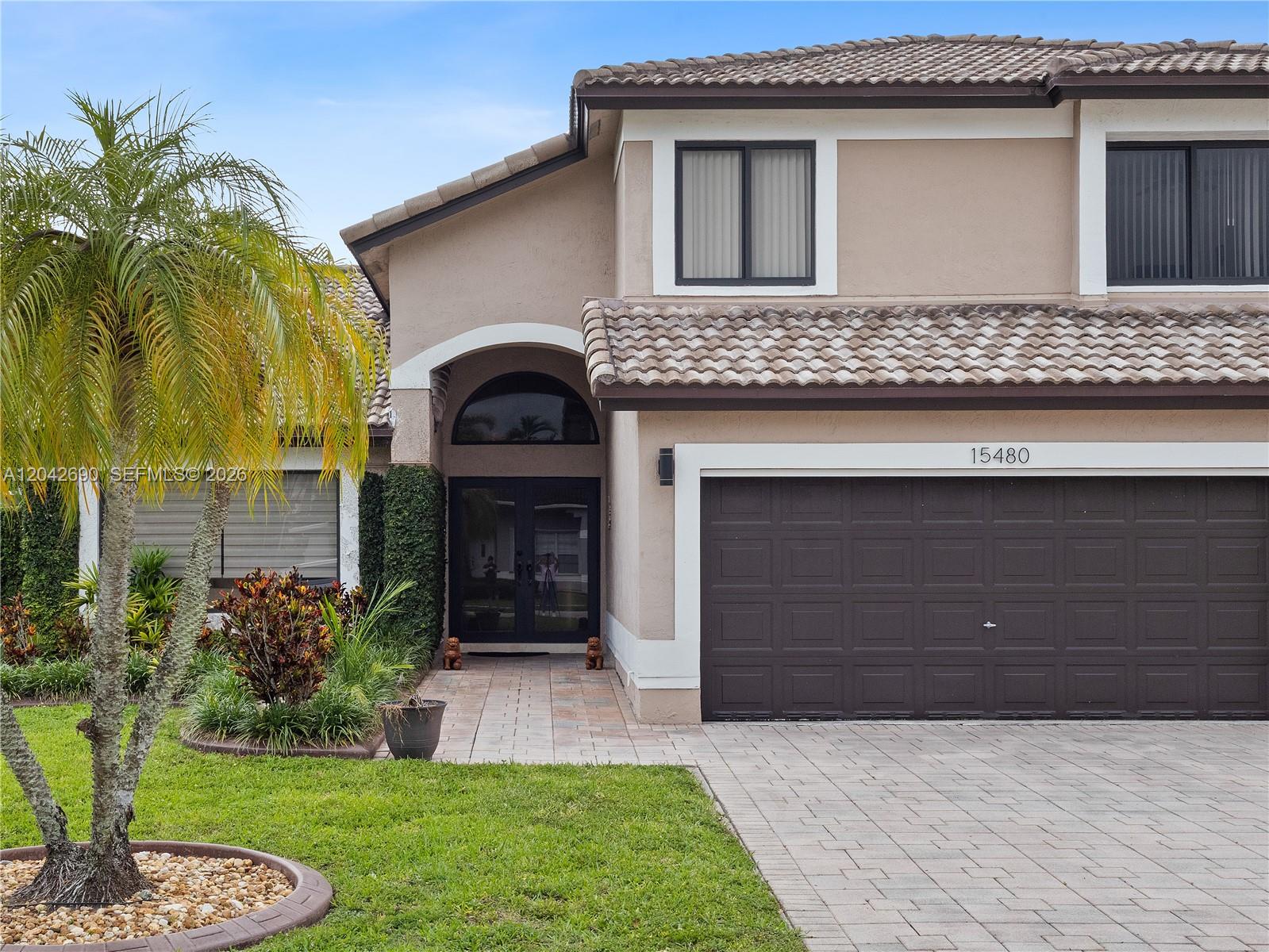 A rectangular swimming pool with a small water feature sits on a paved patio — 15480 SW 148th St, Miami FL 33196, MIAMI, FL