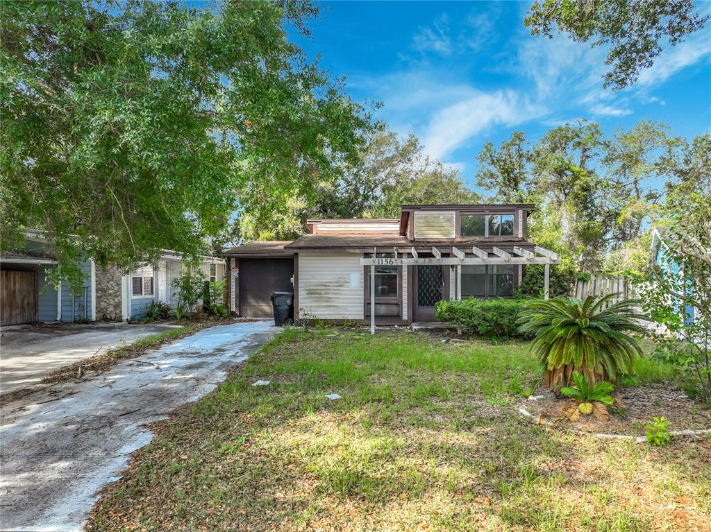 A single-story house with a driveway, a pergola-covered porch, and a large front yard — 1156 ERROL PLACE CIRCLE, APOPKA, FL