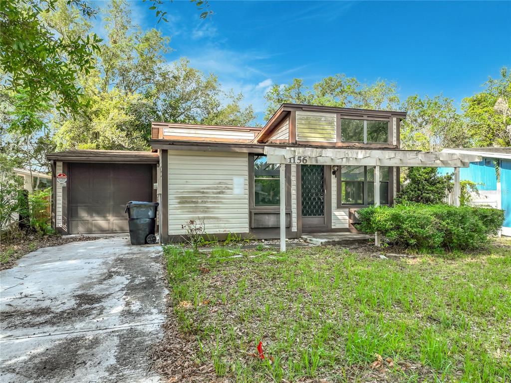A single-story house with a garage, a pergola over the entrance, and a concrete driveway — 1156 ERROL PLACE CIRCLE, APOPKA, FL