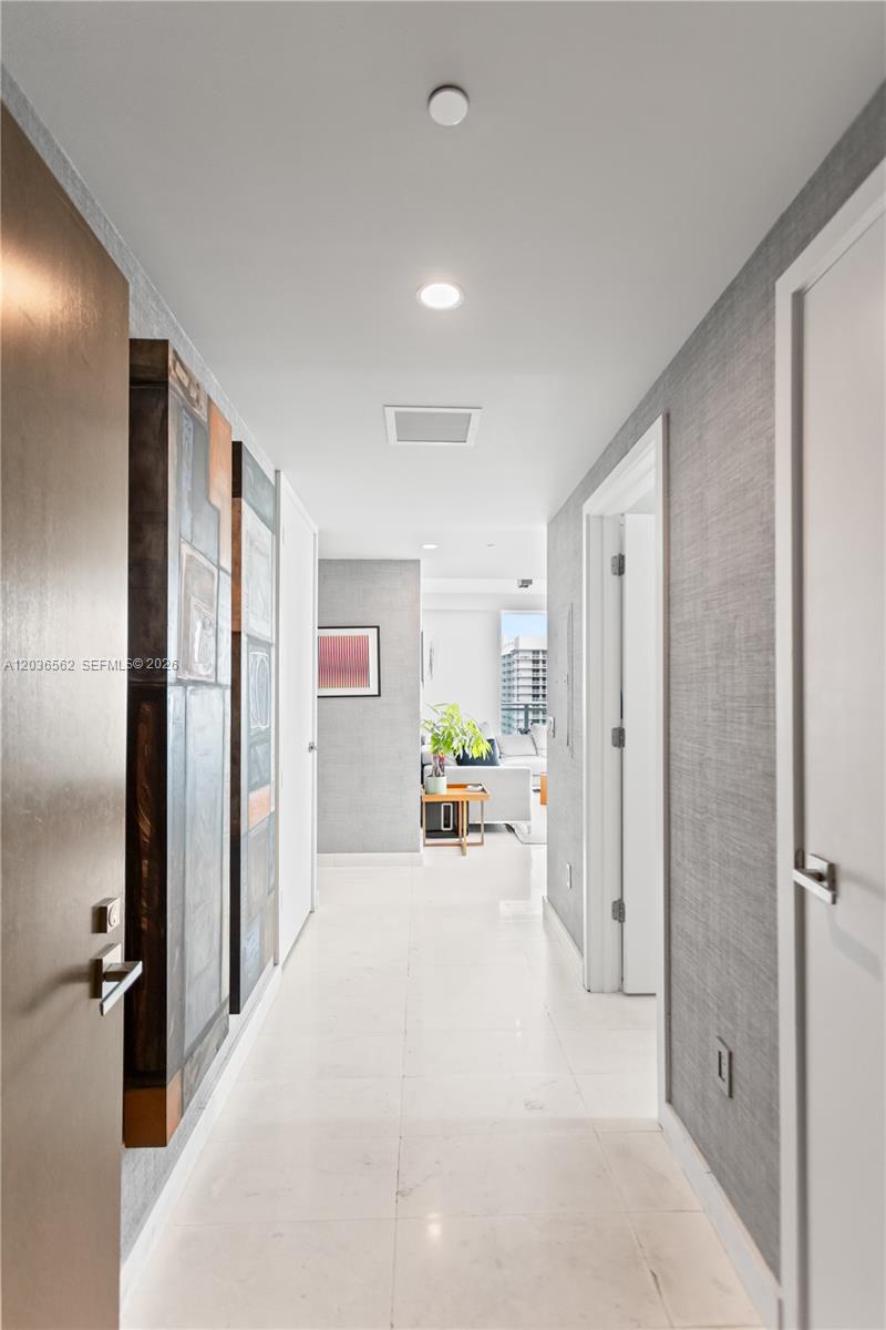 A bright hallway with white tile floors leads to a living area with a balcony — 1080 Brickell Ave # 3300, Miami FL 33131, MIAMI, FL
