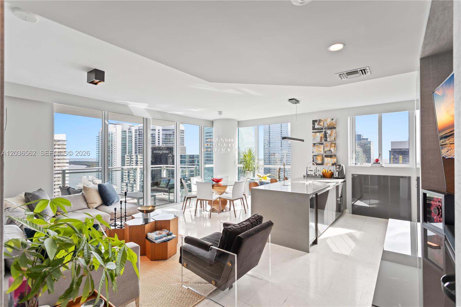 A modern open-concept living and dining area features floor-to-ceiling windows with city and water views — 1080 Brickell Ave # 3300, Miami FL 33131, MIAMI, FL