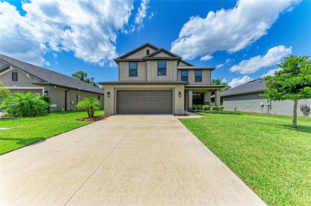 A two-story suburban house with a concrete driveway, a two-car garage, and a green lawn — 9507 43RD COURT E, PARRISH, FL