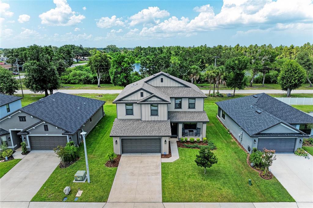 An aerial view shows a two-story suburban house with a gray garage and green lawn — 9507 43RD COURT E, PARRISH, FL