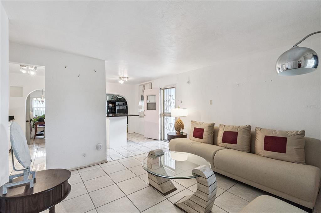 A living room with light tile floors, a beige sofa, and a glass coffee table — 3309 COLEMAN PLACE, ORLANDO, FL