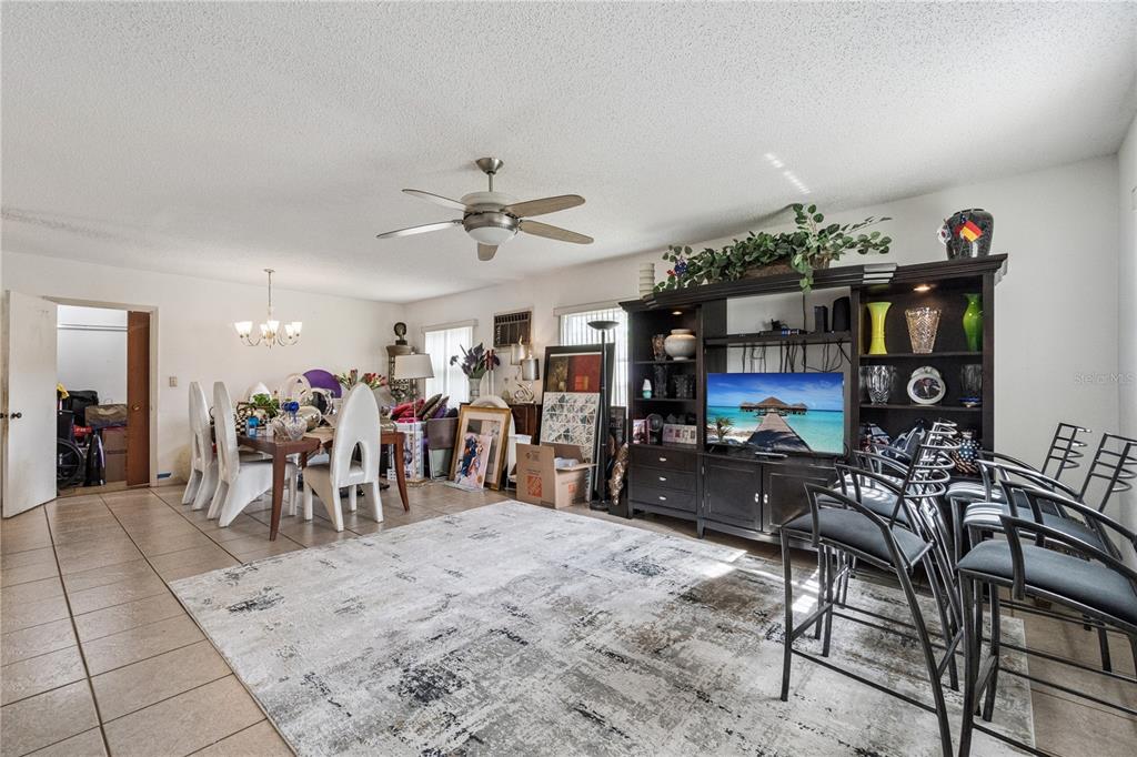 A living and dining area with tile floors, a large entertainment center, and a ceiling fan — 3309 COLEMAN PLACE, ORLANDO, FL