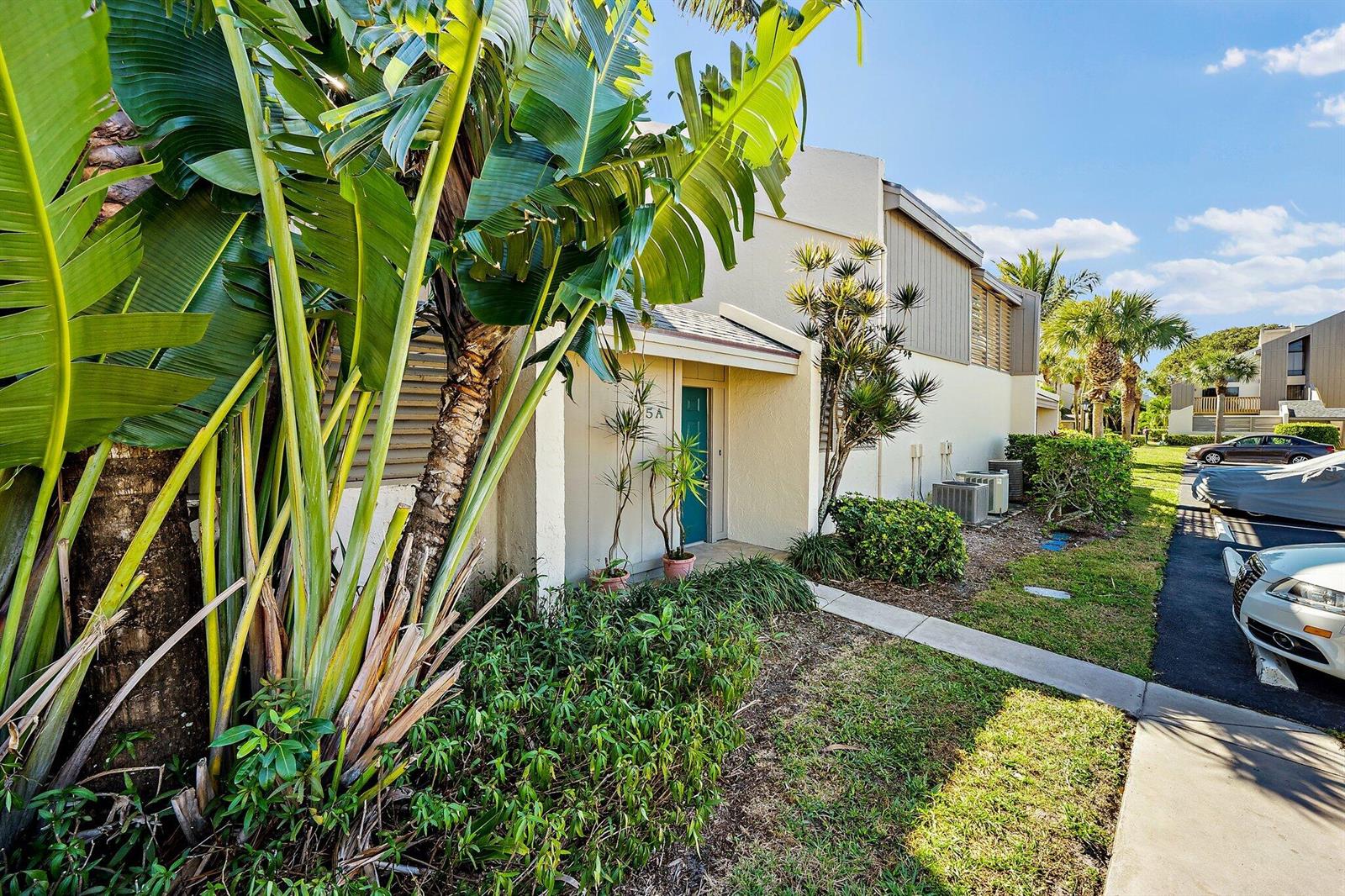 A tan exterior building with a teal front door and large tropical plants in front — 1605 S Us Highway 1 # 5a, Jupiter FL 33477, JUPITER, FL