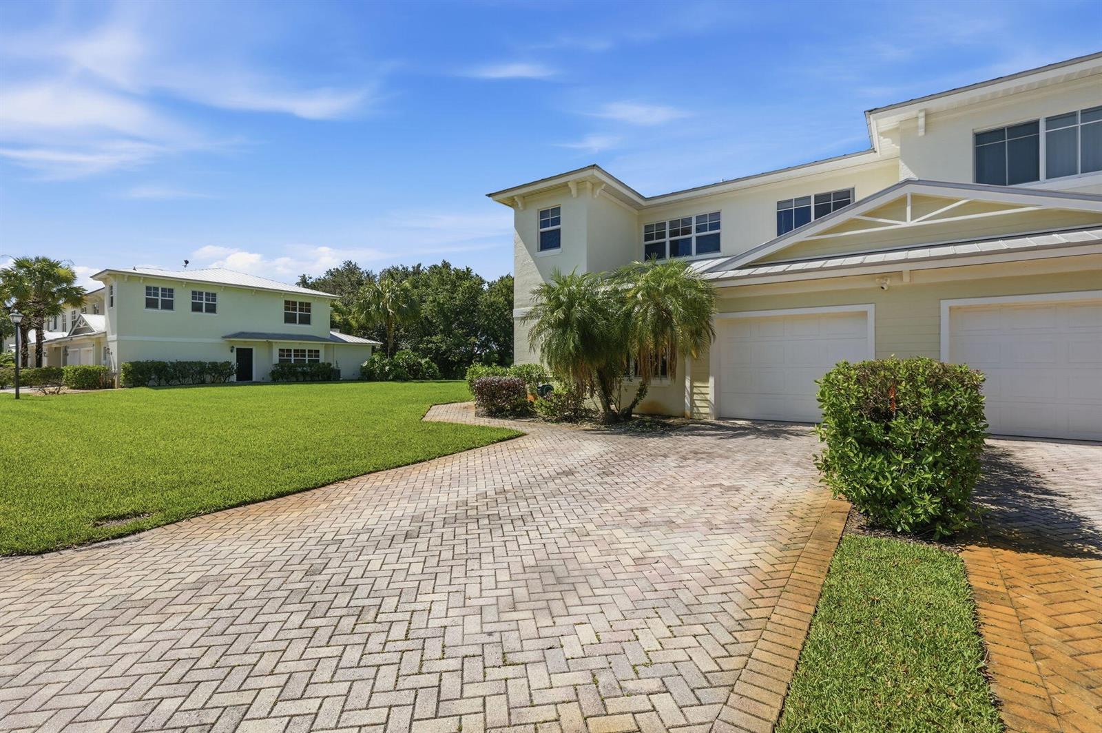 A two-story light yellow house with a brick paver driveway and a two-car garage — 2551 Creekside Drive, Fort Pierce FL 34981, FORT PIERCE, FL