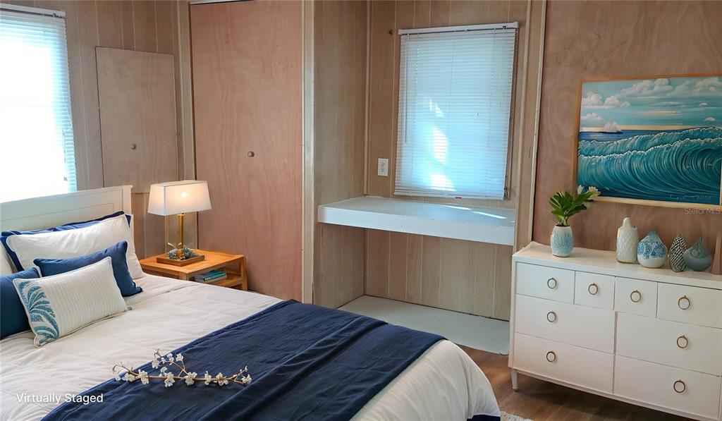 A bedroom features wood-paneled walls, a white dresser, a built-in desk, and a bed — 5410 TAYLOR AVENUE, PORT ORANGE, FL
