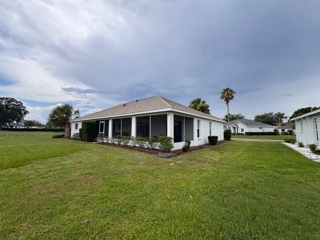 A white house with a screened-in back porch sits on a large, grassy lot — 5126 NW 26TH STREET, OCALA, FL