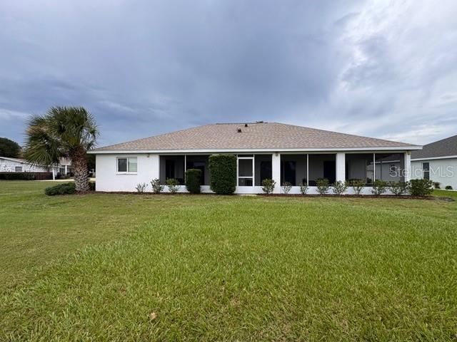The rear exterior of a single-story house features a screened-in lanai and a palm tree — 5126 NW 26TH STREET, OCALA, FL