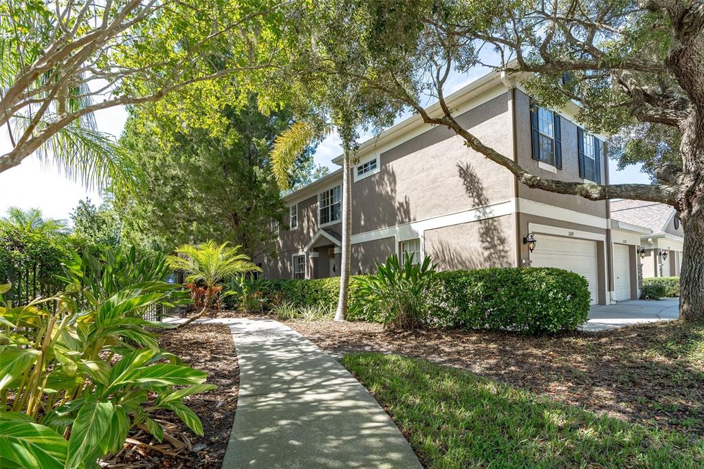 A concrete walkway leads to the entrance of a two-story townhouse with a garage — 11269 WINDSOR PLACE CIRCLE, TAMPA, FL