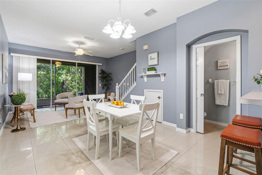 A dining area with a white table and chairs sits next to a living space — 11269 WINDSOR PLACE CIRCLE, TAMPA, FL