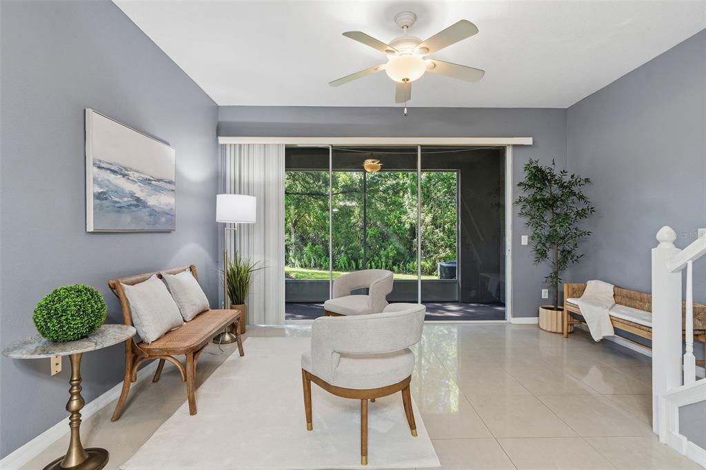 A living room features light gray walls, tile flooring, a ceiling fan, and sliding glass doors — 11269 WINDSOR PLACE CIRCLE, TAMPA, FL