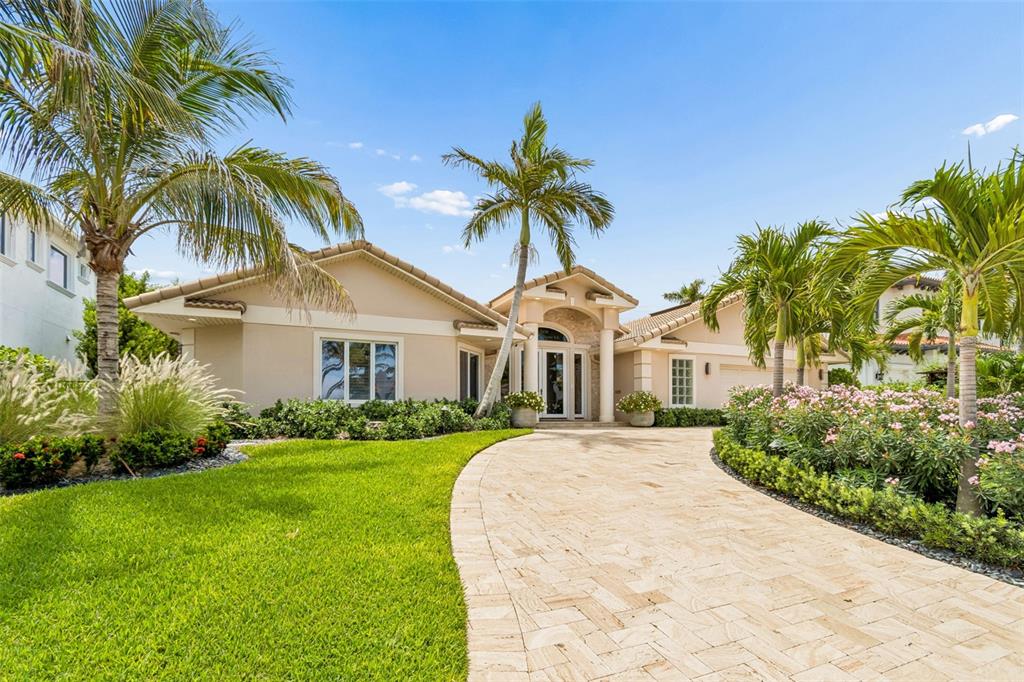 A single-story house with a beige exterior, stone entryway, and a paved driveway with palms — 2038 CAROLINA AVENUE NE, ST PETERSBURG, FL