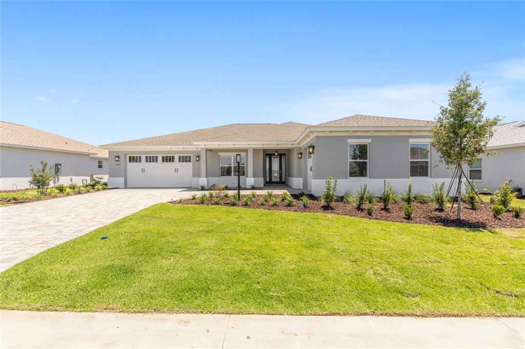 A single-story house with a gray exterior, a two-car garage, and a landscaped front yard — 10252 SW 85TH PLACE ROAD, OCALA, FL