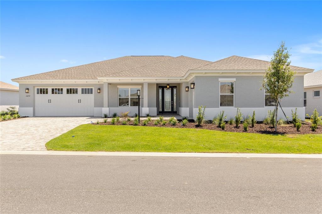 A single-story house with a gray stucco exterior, a two-car garage, and a paved driveway — 10252 SW 85TH PLACE ROAD, OCALA, FL