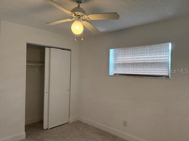 A bedroom features a ceiling fan, a closet with sliding doors, and a window with blinds — 27127 FERNERY AVENUE, BROOKSVILLE, FL