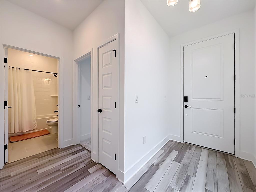 An entryway features wood-look flooring, a white front door, and two interior doors — 13568 AUTUMN HARVEST AVENUE, WINTER GARDEN, FL