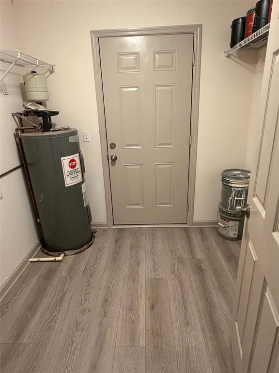 A utility room features a water heater, a door, and paint buckets on the floor — 4255 43RD AVENUE N, ST PETERSBURG, FL