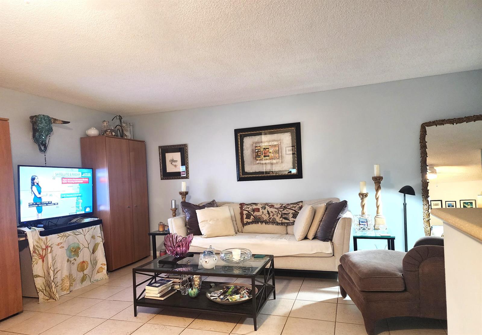 A living room features a beige sofa, a glass coffee table, and a television cabinet — 804 SE 7th Street # 101, Deerfield Beach FL 33441, DEERFIELD BEACH, FL