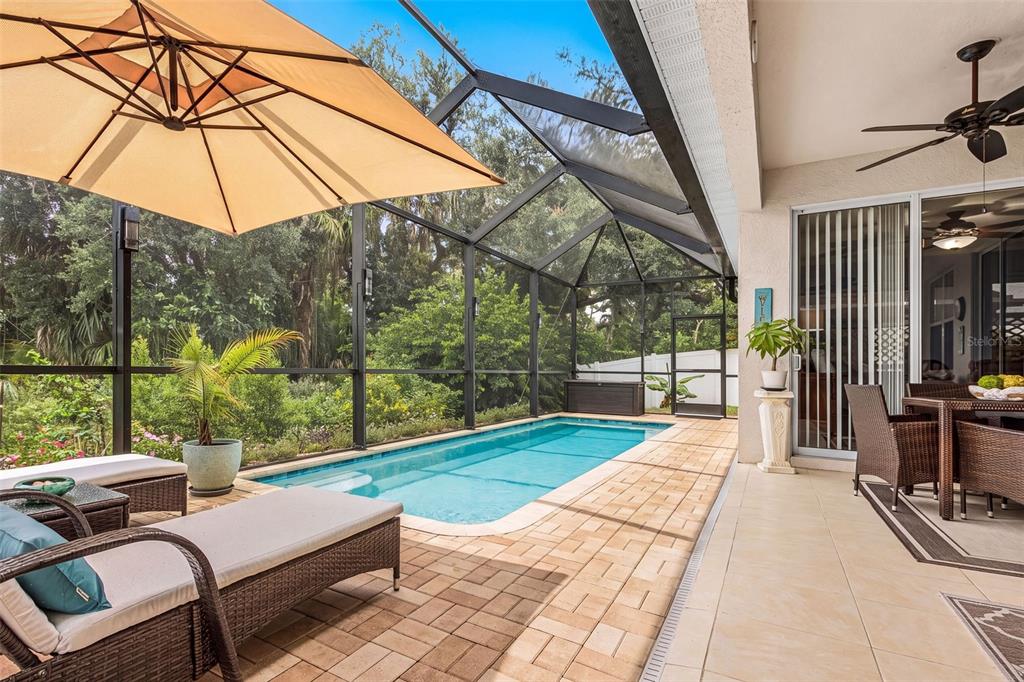 A screened-in patio features a rectangular swimming pool, lounge chairs, and a dining set — 3111 43RD AVENUE E, BRADENTON, FL