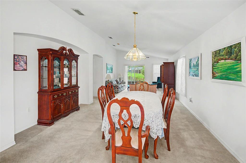 A dining room features a wooden hutch, a table with chairs, and a chandelier — 364 ACADIA DR, POINCIANA, FL