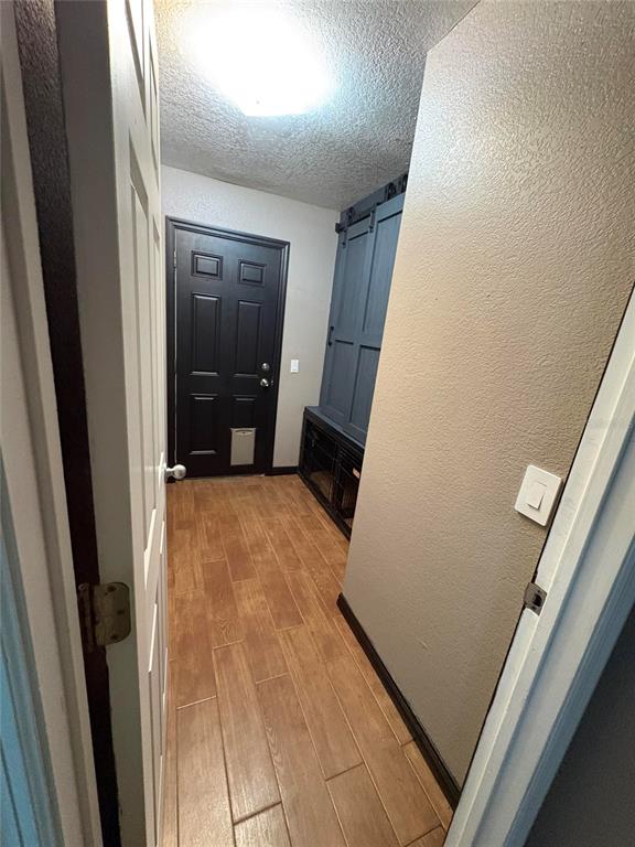 A hallway with wood-look tile flooring, a black door with a pet flap, and built-in cabinetry — 2 FT CLINCH HEIGHTS ROAD, FROSTPROOF, FL