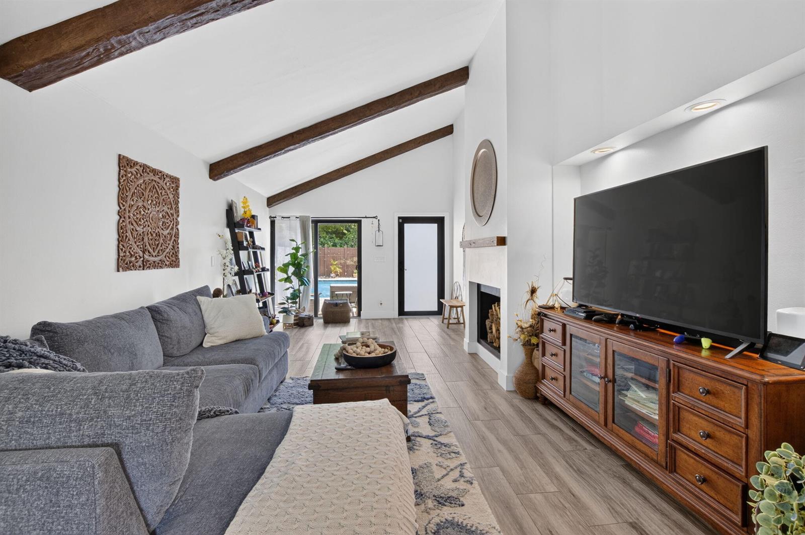 A living room features vaulted ceilings with exposed wood beams, a fireplace, and wood flooring — 5918 Patio Drive, Boca Raton FL 33433, BOCA RATON, FL