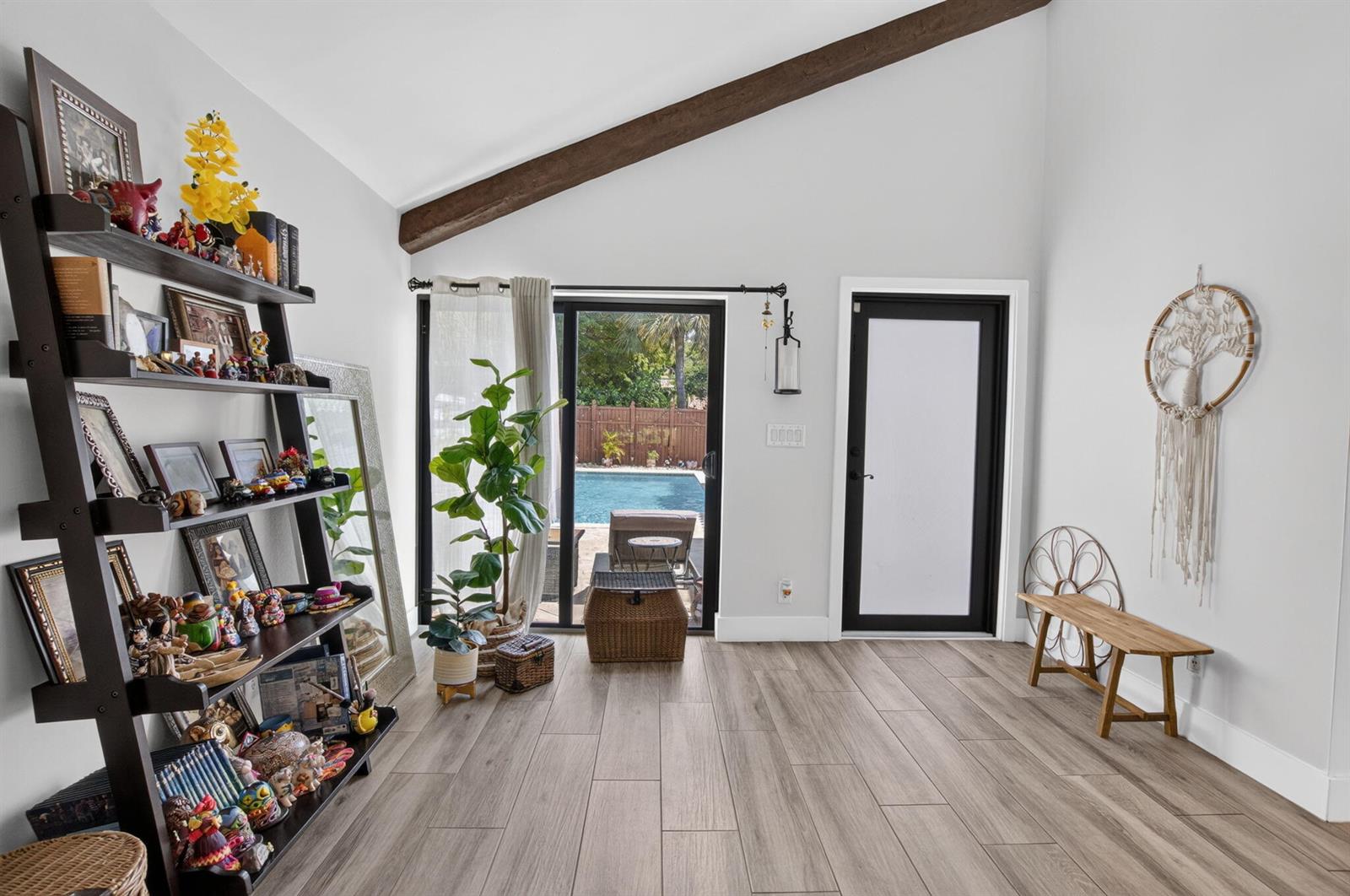 A room with wood-look tile flooring, a sloped ceiling with a beam, and a pool view — 5918 Patio Drive, Boca Raton FL 33433, BOCA RATON, FL