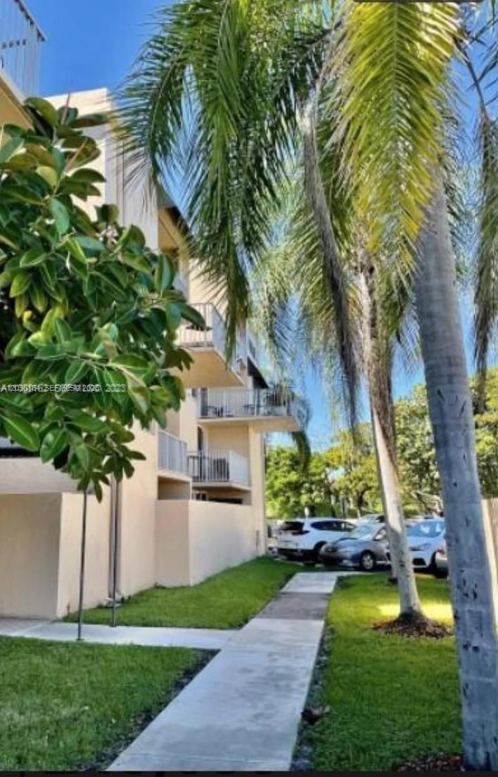A multi-story apartment building exterior features balconies, a concrete walkway, and surrounding palm trees — 10801 SW 109th Ct # D412, Miami FL 33176, MIAMI, FL