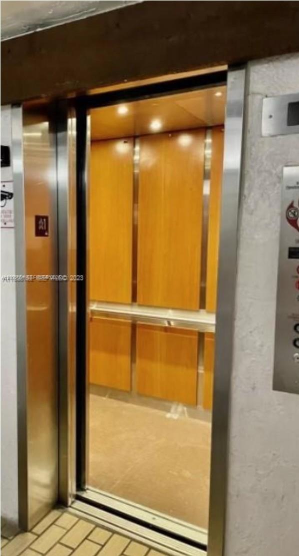 An open elevator with wood-paneled walls and a metal handrail — 10801 SW 109th Ct # D412, Miami FL 33176, MIAMI, FL