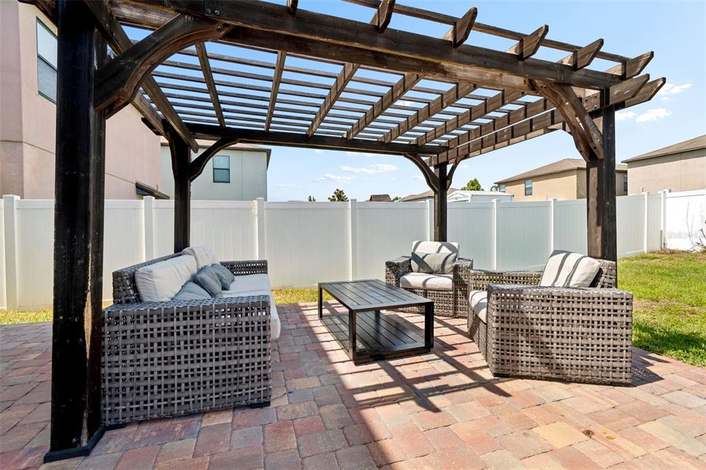 A wooden pergola covers a patio with wicker furniture and a coffee table — 13917 ARBOR PINES DRIVE, RIVERVIEW, FL