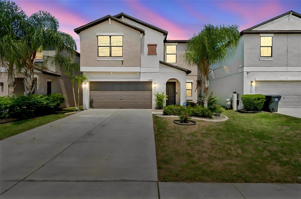 A two-story suburban house features a concrete driveway, a garage, and a landscaped front yard — 13917 ARBOR PINES DRIVE, RIVERVIEW, FL