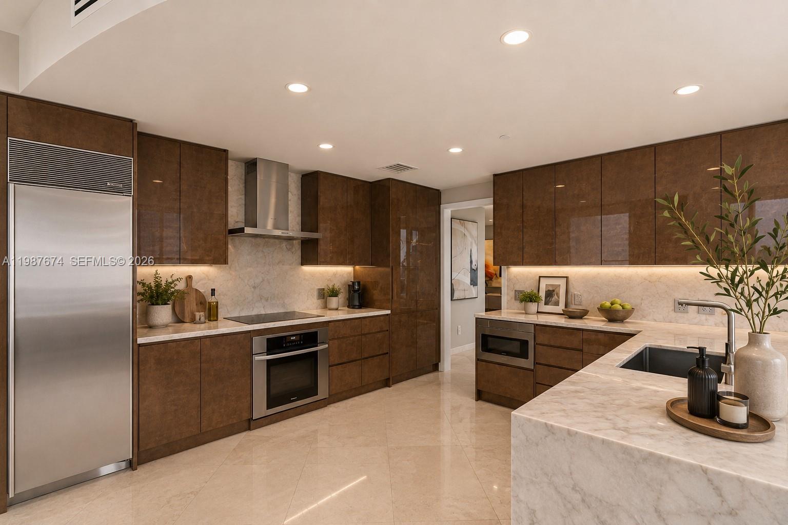 A modern kitchen features brown glossy cabinets, marble countertops, and stainless steel appliances — 901 Brickell Key Blvd # 2804, Miami FL 33131, MIAMI, FL