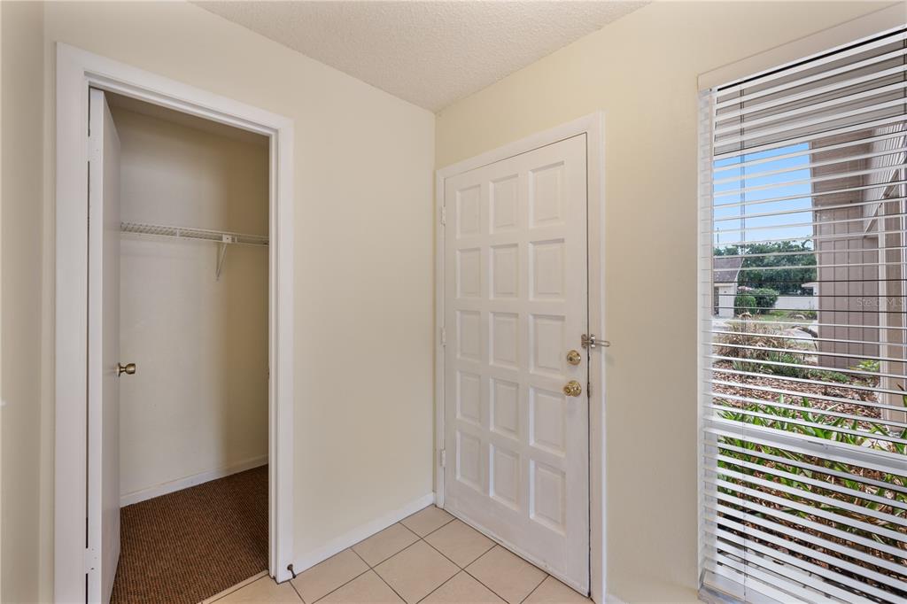 An entryway with a tiled floor, a closet, a white door, and a window with blinds — 4231 OAK LOOP UNIT 51, MULBERRY, FL