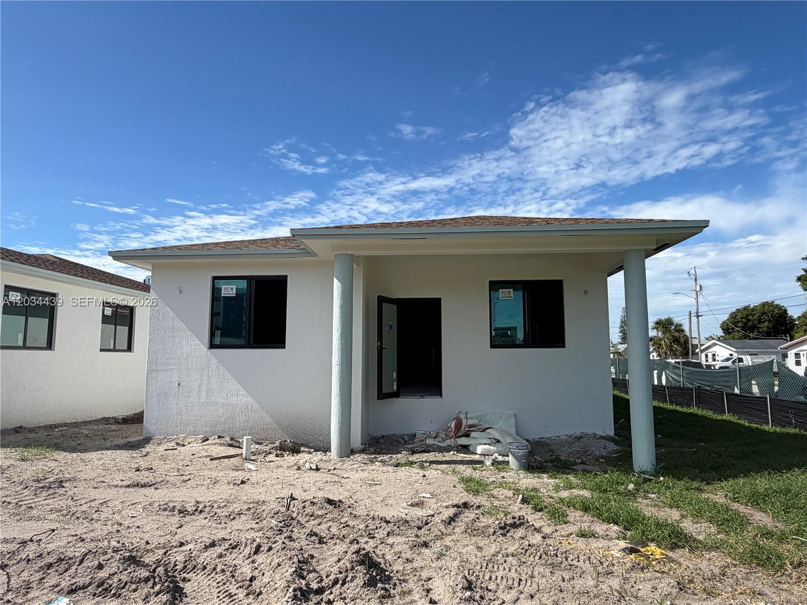 A newly constructed, single-story white house with a covered porch and two front columns — 344 NW 11th St, Pompano Beach FL 33060, POMPANO BEACH, FL