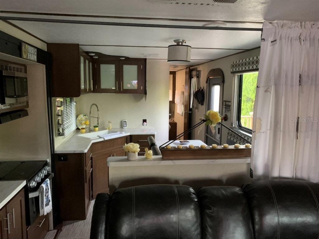 A view of a kitchen and living area inside a recreational vehicle — 650 CENTER CREST BOULEVARD, DAVENPORT, FL